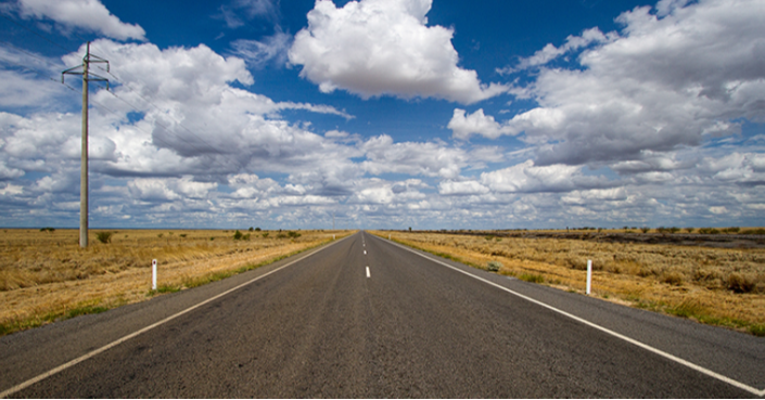 A photograph shows an empty road that continues toward the horizon.