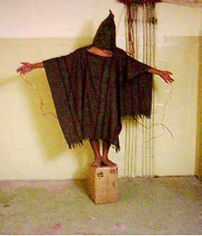 Picture of an individual standing on a box with outstretched arms wearing a poncho covering and a hood over their head.
