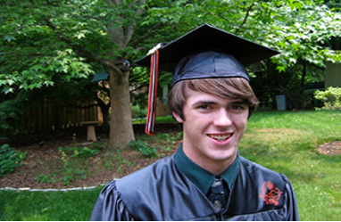 A photo shows a smiling person wearing a graduation cap and gown.