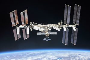 A view of the international space station taken from an approaching space craft. The crew modules are in the center with extended solar panels towards the extremities of the station