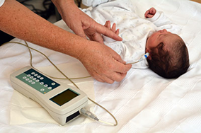Infant auditory testing being done with Otoacoustic Emissions (OAE) test.
