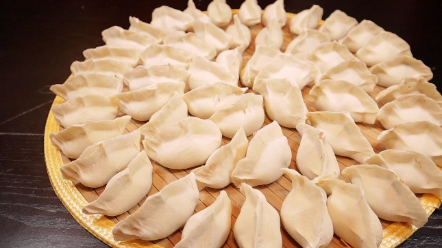 Three rings increasing in size of dumplings on a round plate.