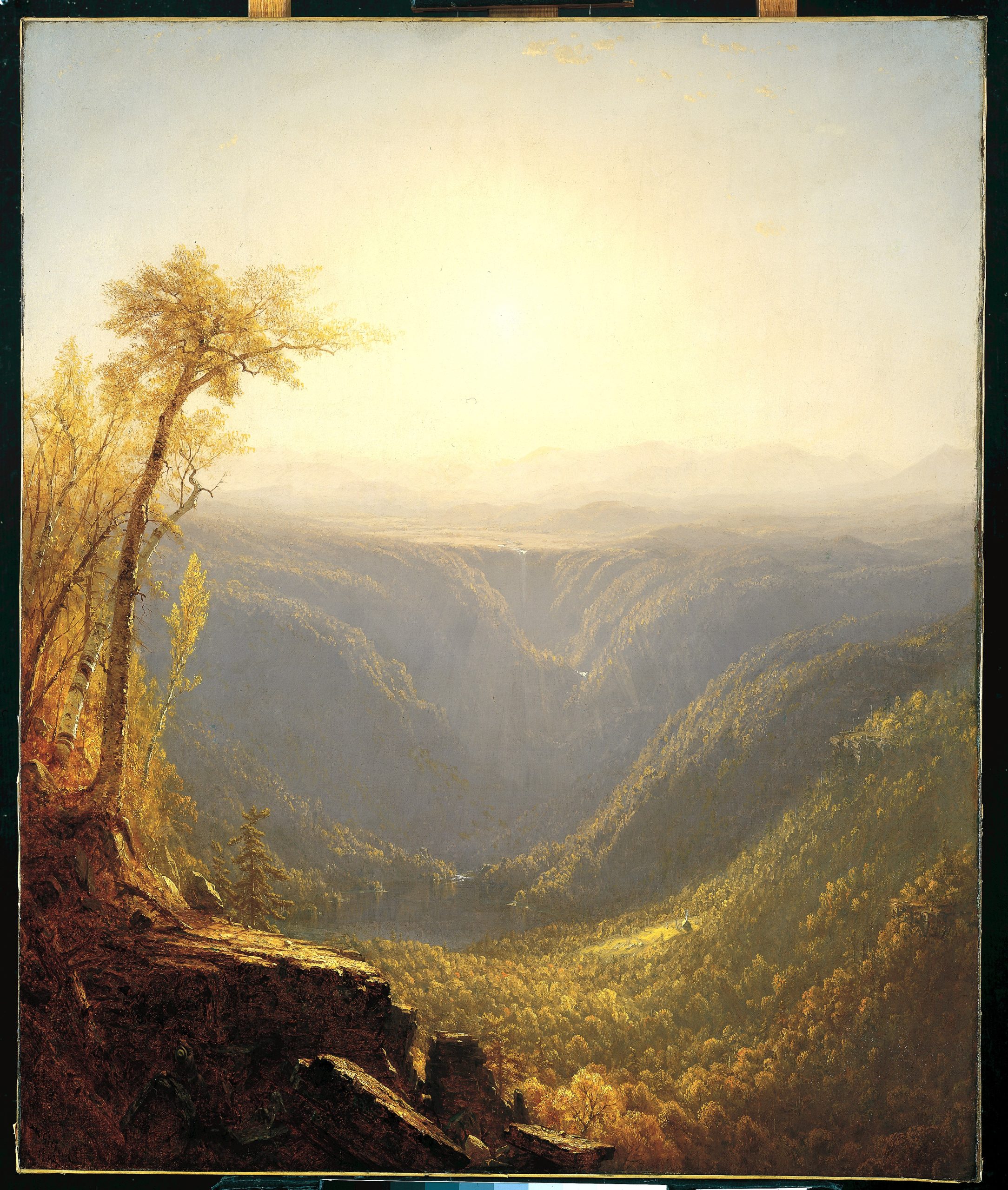 view of a gorge between mountains with a hazy sun in the distance