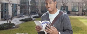 Student in LaGuardia's courtyard reading a book