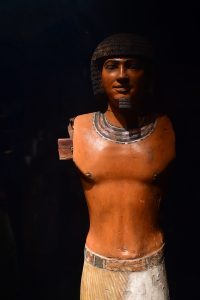 an ancient Egyptian statue of a bare-chested man