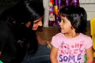 Woman of color with small child of color in a classroom setting