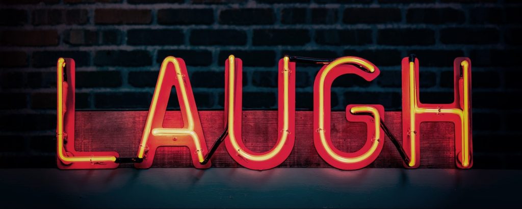 Neon sign that reads "LAUGH"