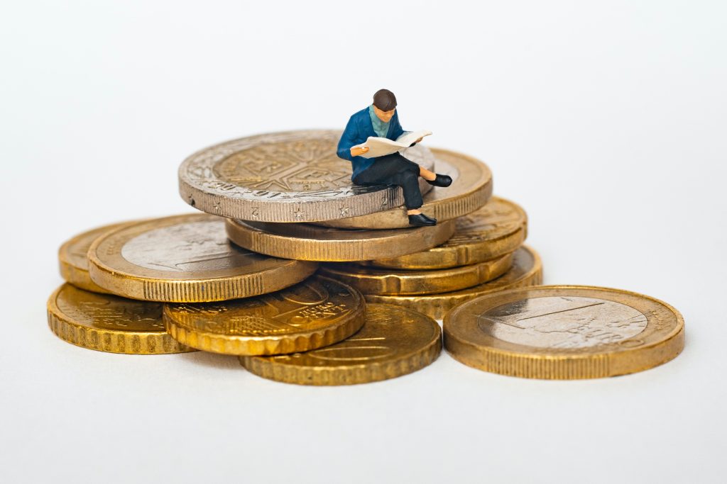 Man sitting on piles of money, just reading his paper.