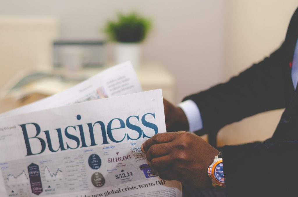 Businessman opening a newspaper.