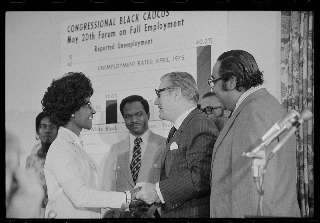 at a Congressional Black Caucus on full employment, Rep Chisholm chaking hands with Gov Rockefeller and others