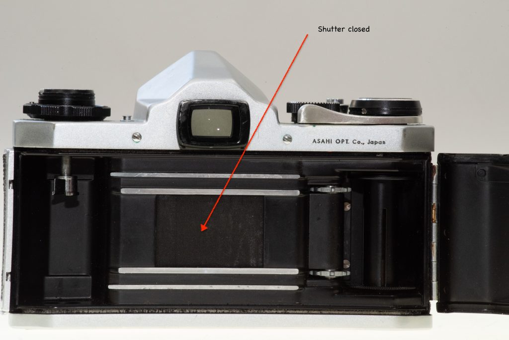 35mm SLR camera, back open showing shutter curtain close