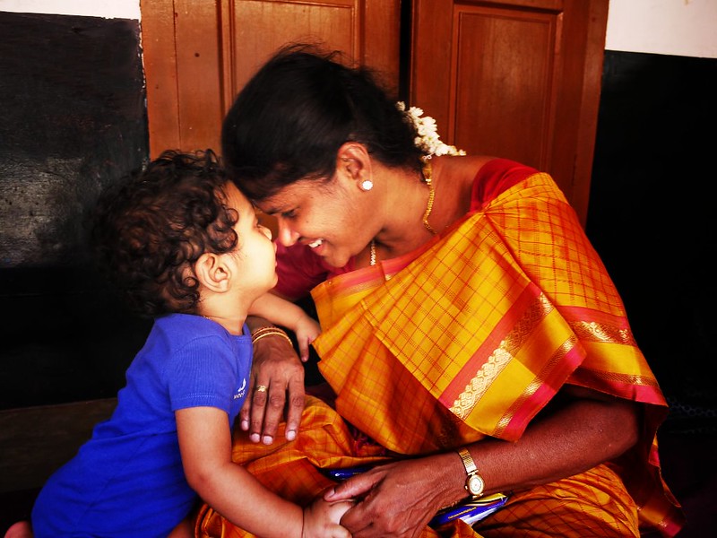 Photo of mother and son holding hands and embracing.