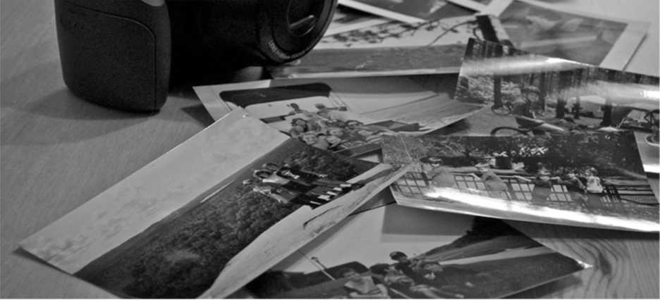 A photograph shows a camera and a pile of photographs.