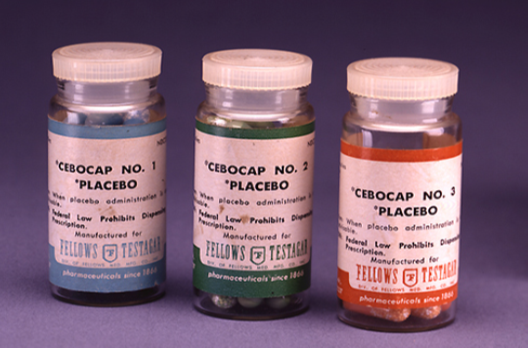 A photograph shows three glass bottles of pills labeled as placebos.