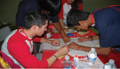 A picture shows four people gathered around a table attempting to figure out a problem together.