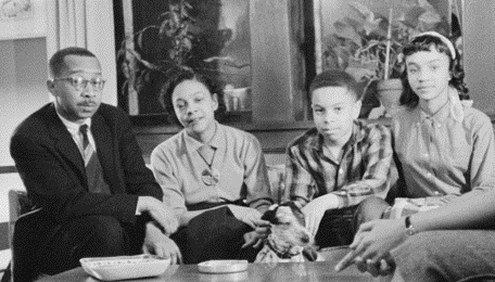 From left to right Kenneth Clark, Mamie Phipps Clark, their son and daughter. The family is sitting in their living room on the couch.