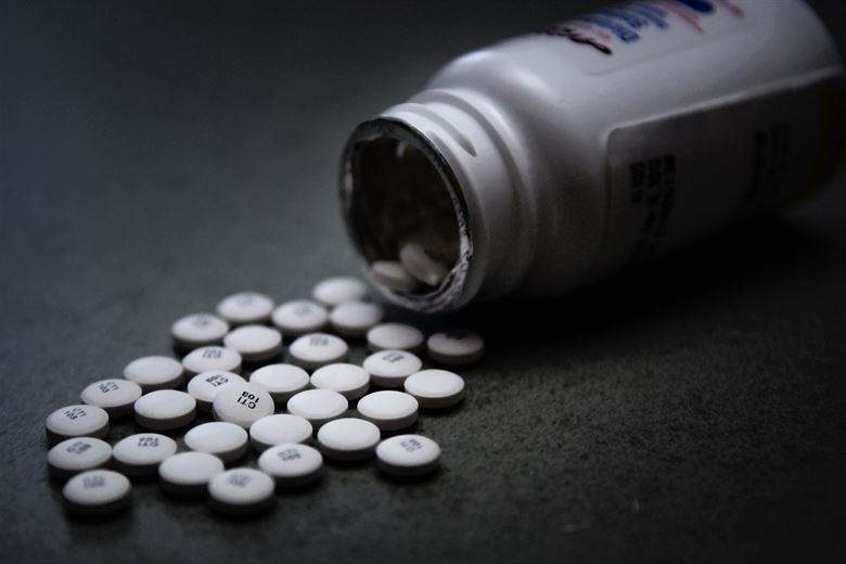 pills spilling out of a bottle with an ominous color scheme