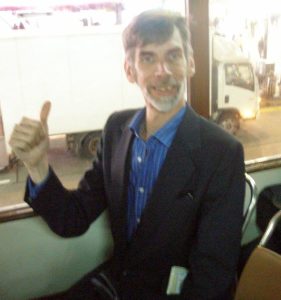 Man sitting on a bus giving thumbs up
