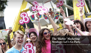 Young women waving B for Barbie signs to demonstrate the Barbie movie marketing machine.