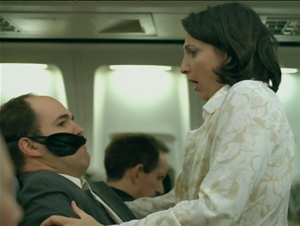 A woman accidentally sits on a man's lap due to air turbulence. Used in a Super Bowl commercial for a campaign called Don't Judge.